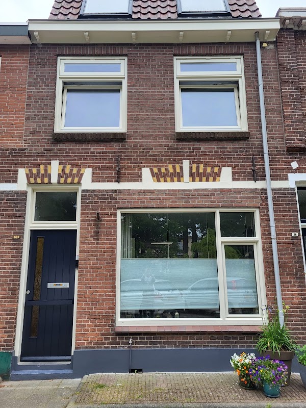 Gevel met opnieuw geschilderde crèmekleurige kozijnen en donkerblauwe voordeur.